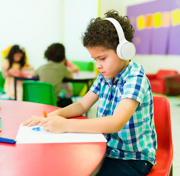 Child with headphones colouring